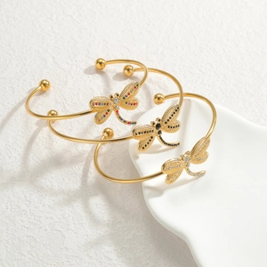 Minimalist 18K gold plated dragonfly bangle with sparkling rhinestones on white tray