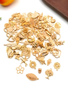 Close-up of golden alloy charm assortment featuring tree of life, birds, and star designs