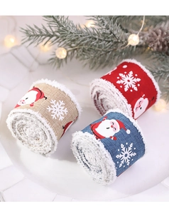 Close-up of Christmas ribbon with Santa and snowflake motifs on festive wooden tray