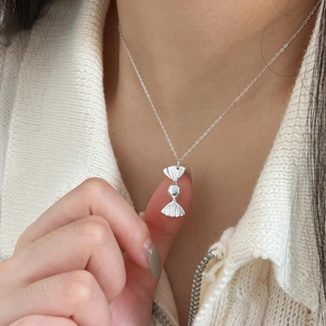 Macro di una collana con ciondolo a caramella in argento sterling 925 su una modella