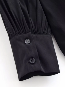 Detailed macro view of black long sleeve shirt cuff with double buttons and pleats