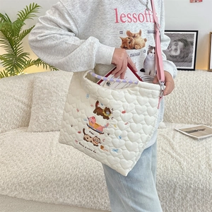 Detail of heart quilted cotton shoulder bag with cat embroidery and pink woven strap