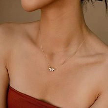 Close-up of double-layer snake bone chain necklace with fan-shaped pendant on neck