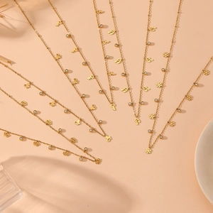 Elegant gold necklaces with snowflake and butterfly pendants on aesthetic background