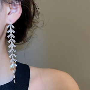 Gros plan détaillé de boucles d'oreilles à pompons en zircon et feuilles sur mannequin