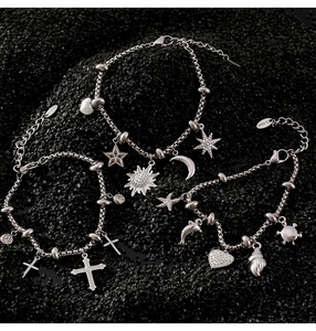 Detail of silver stainless steel bracelets with celestial, religious and ocean charms