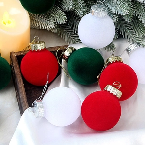 Close-up of velvet Christmas balls in red and white on a tray with festive decor