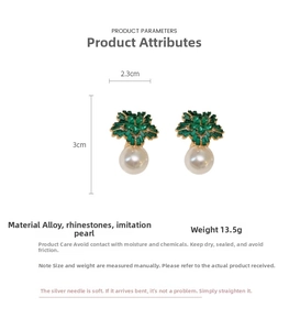 Detail view of flower-shaped green crystal earrings with white imitation pearls and sizes