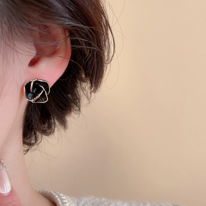 Gros plan détaillé d'une boucle d'oreille rose noire vintage avec détails dorés