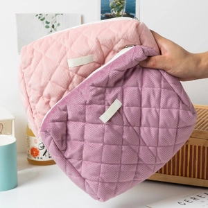 Vue détaillée de trousses à maquillage en velours côtelé matelassé rose et violet