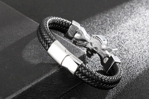 Macro shot of punk style braided black leather bracelet with silver skull magnetic clasp