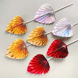 Detail view of 7 shiny folding fan cake toppers in gold, red and iridescent colors