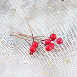Detail of glossy 8mm red artificial berries on stems for festive floral decoration