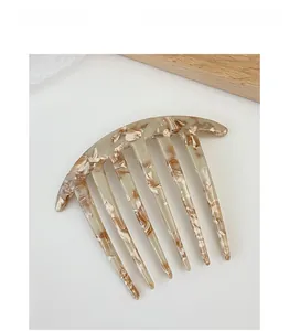 Detailed view of a vintage acetate hair comb with amber tortoiseshell pattern and seven teeth