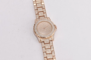 Macro shot of rose gold women's watch featuring a full diamond encrusted metal band