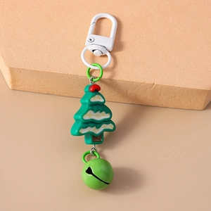 Detail of green Christmas tree keychain with a matching metal bell and white clasp