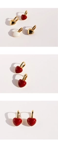 Close-up of vintage heart earrings in red, white and gold finishes with metal hoops