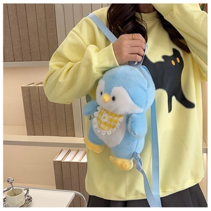 Close-up of blue plush penguin backpack featuring adjustable straps and floral bib detail