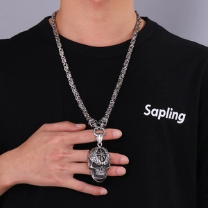 Gothic punk silver skull pendant with vintage woven chain on male model neck