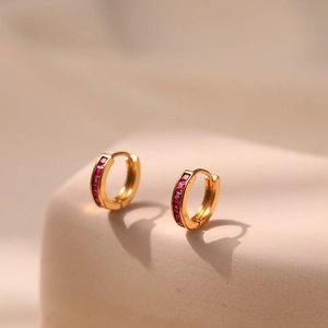 Macro shot of 18K gold plated hoop earrings featuring square red zircons in channel setting