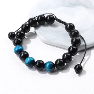 Macro detail of 10mm tiger eye and black glass beads on adjustable braided bracelet