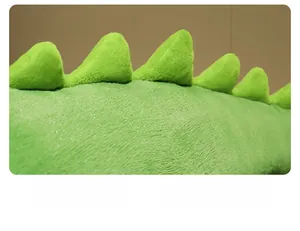 Gros plan sur la peluche crocodile verte montrant la texture et les ailerons dorsaux