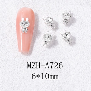 Vue macro de bijoux d'ongles lapin en argent avec zircons sur ongle rose