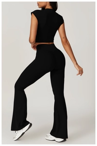 Detail of black cross-back crop top and high-waisted flare yoga pants on model