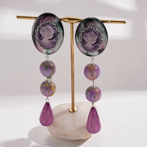Detailed close-up of retro resin drop earrings with portrait relief and purple beads