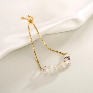 Detail of adjustable gold box chain with natural white raw stones on white silk