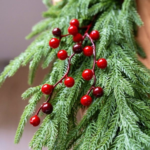 Artificial Christmas red berries with realistic green pine needles for holiday decoration