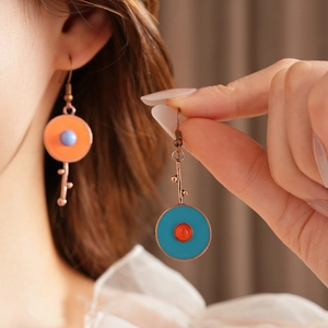 Detail view of vintage asymmetric enamel earrings with colorful round charms and key pendant