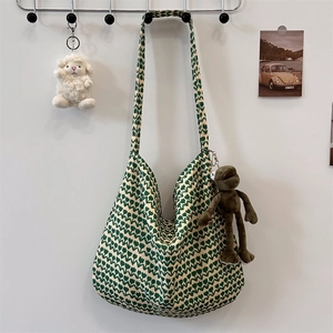 Detail of floral canvas tote bag featuring green tulip patterns and cute plush pendants