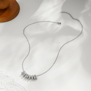 Close-up of silver necklace featuring MAMA pendant with micro-inlaid sparkling zircons