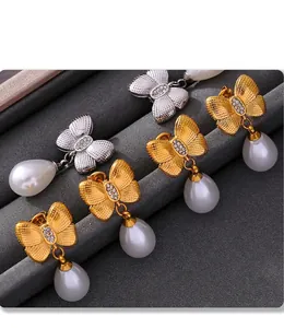 Macro shot of PVD plated butterfly earrings with drop pearls and sparkling rhinestones