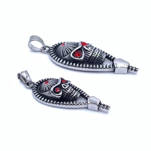 Macro shot of skull pendant with red gemstone eyes and zipper detail on stainless steel
