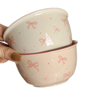 Set of two ceramic bowls with cute pink bows and polka dots patterns on white background