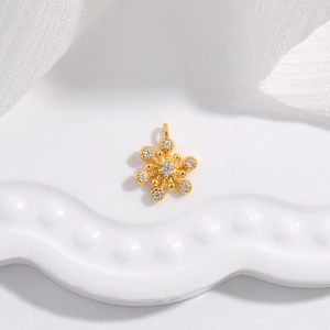 Elegant gold snowflake pendant with sparkling zircons on white ceramic tray