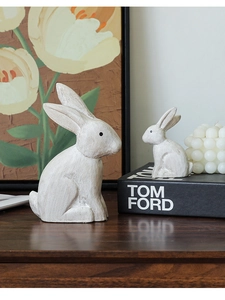 Macro detail of two minimalist resin rabbit statues with a rustic wood-like finish