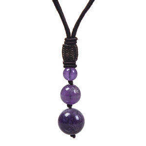 Vue détaillée de trois perles d'améthyste violette sur un cordon de collier tressé bicolore