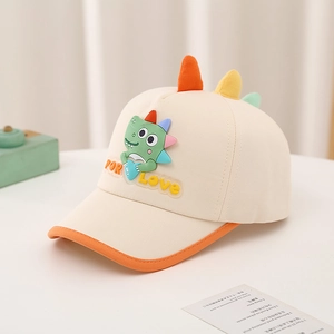 Detail showing cartoon dinosaur patch and colorful 3D horns on cream canvas kid hat