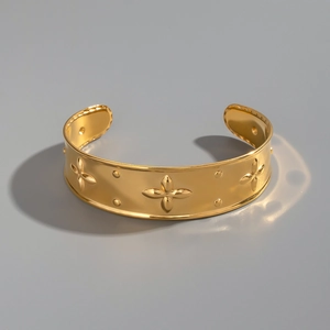 Detail of 18K gold-plated stainless steel cuff featuring embossed floral texture and patterns
