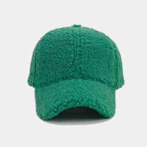 Close-up of green teddy fleece fabric texture on a warm winter baseball cap