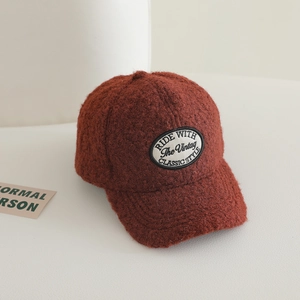 Detailed texture of rust red sherpa fleece fabric on a winter baseball cap