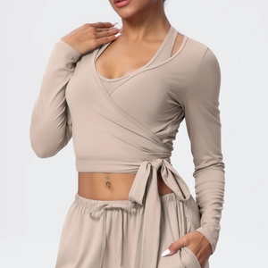 Detail of beige long-sleeve yoga top with cross-wrap design and side-tie knot detail