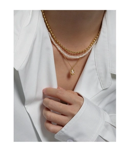Close-up of three-layered S925 silver necklace with baroque pearl and golden beads