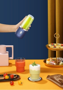Handheld portable blue blender filled with fresh green juice in an aesthetic tea scene