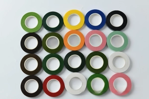 Flat lay of 20 assorted colors of floral tape rolls with wrinkled paper texture on white background