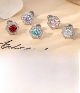 Détails macro de boucles d'oreilles hexagonales en zircon avec dimensions en acier titane