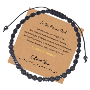 Détail d'un bracelet code Morse en pierre de lave noire sur une carte cadeau en kraft